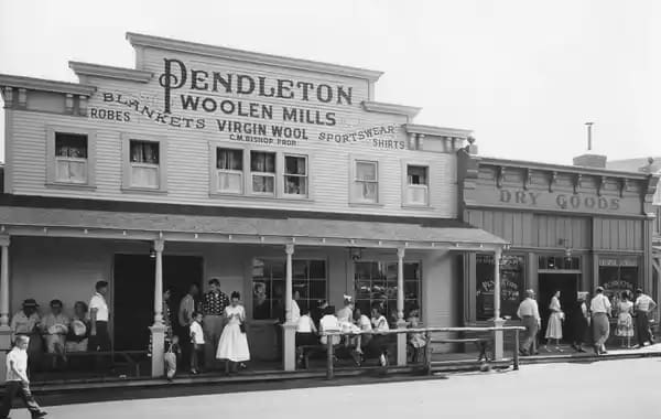 Historic photo of Pendleton Woolen Mills storefront with workers outside.