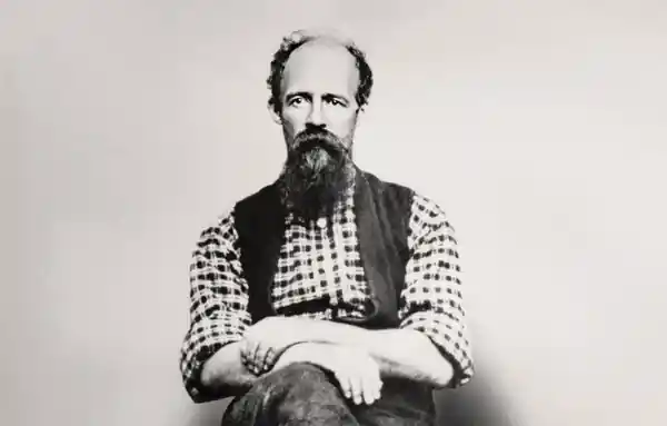 Black and white portrait of a bearded man in a checkered shirt.