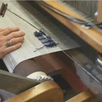 Person sketching a figure on paper with a pen.