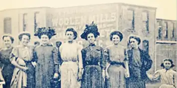 Black and white photo of five women in vintage dresses and hats.