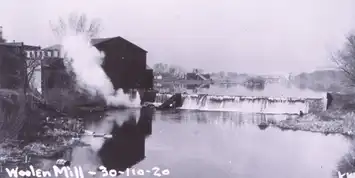 A building collapses into a body of water, creating a large splash.